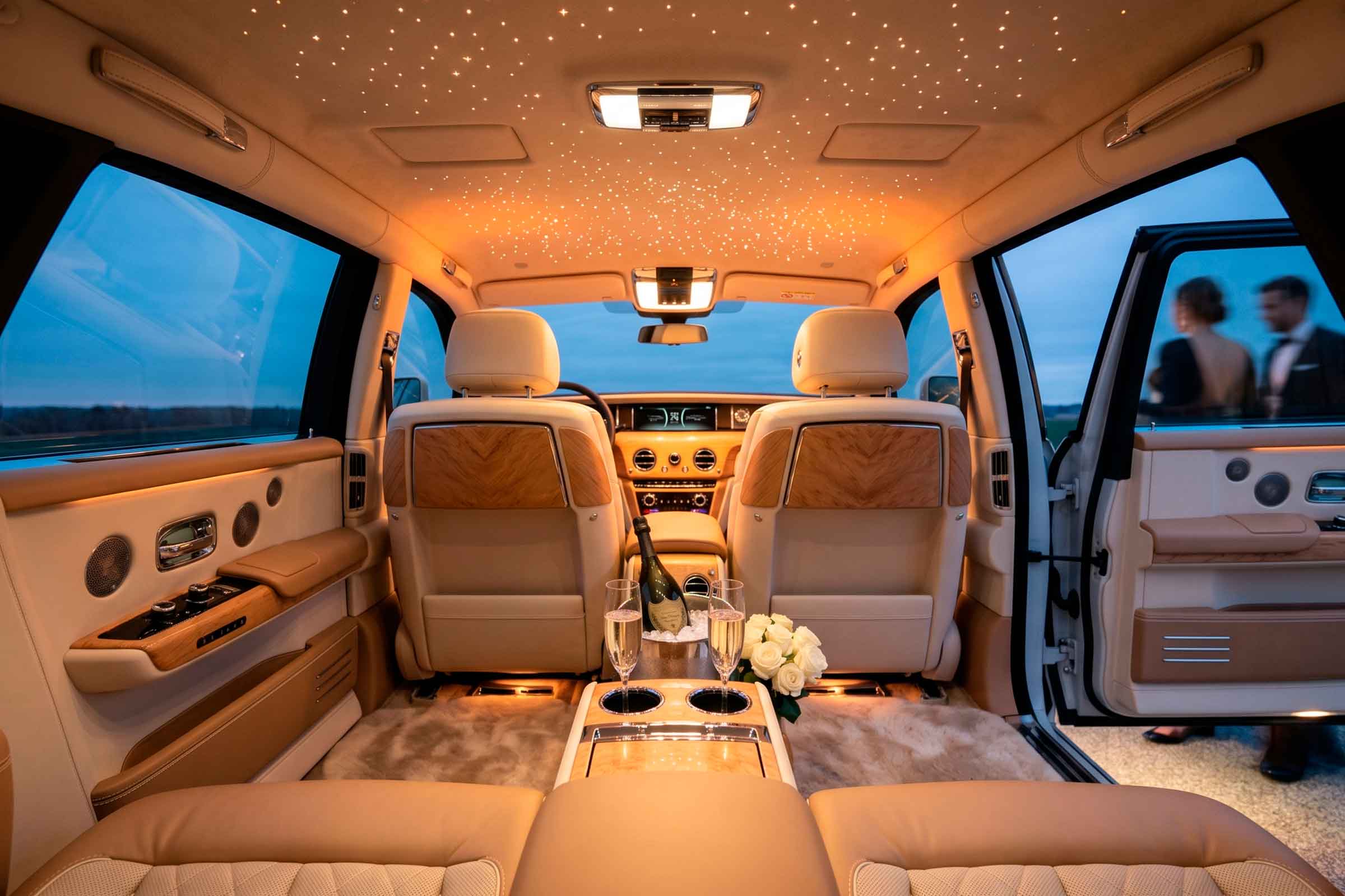 Chauffeur holding open door of luxury black car