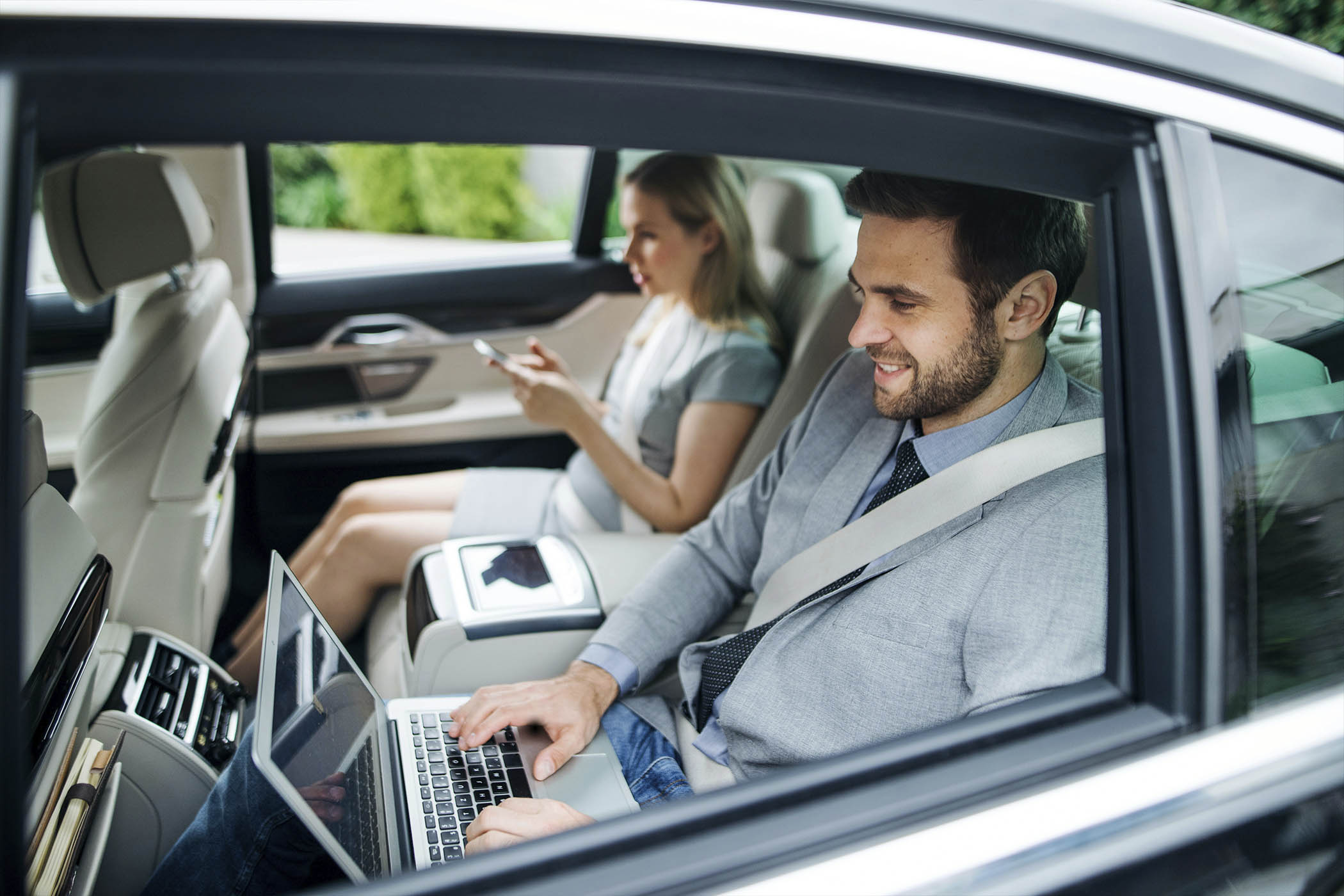 Chauffeur helping a passenger into a black car